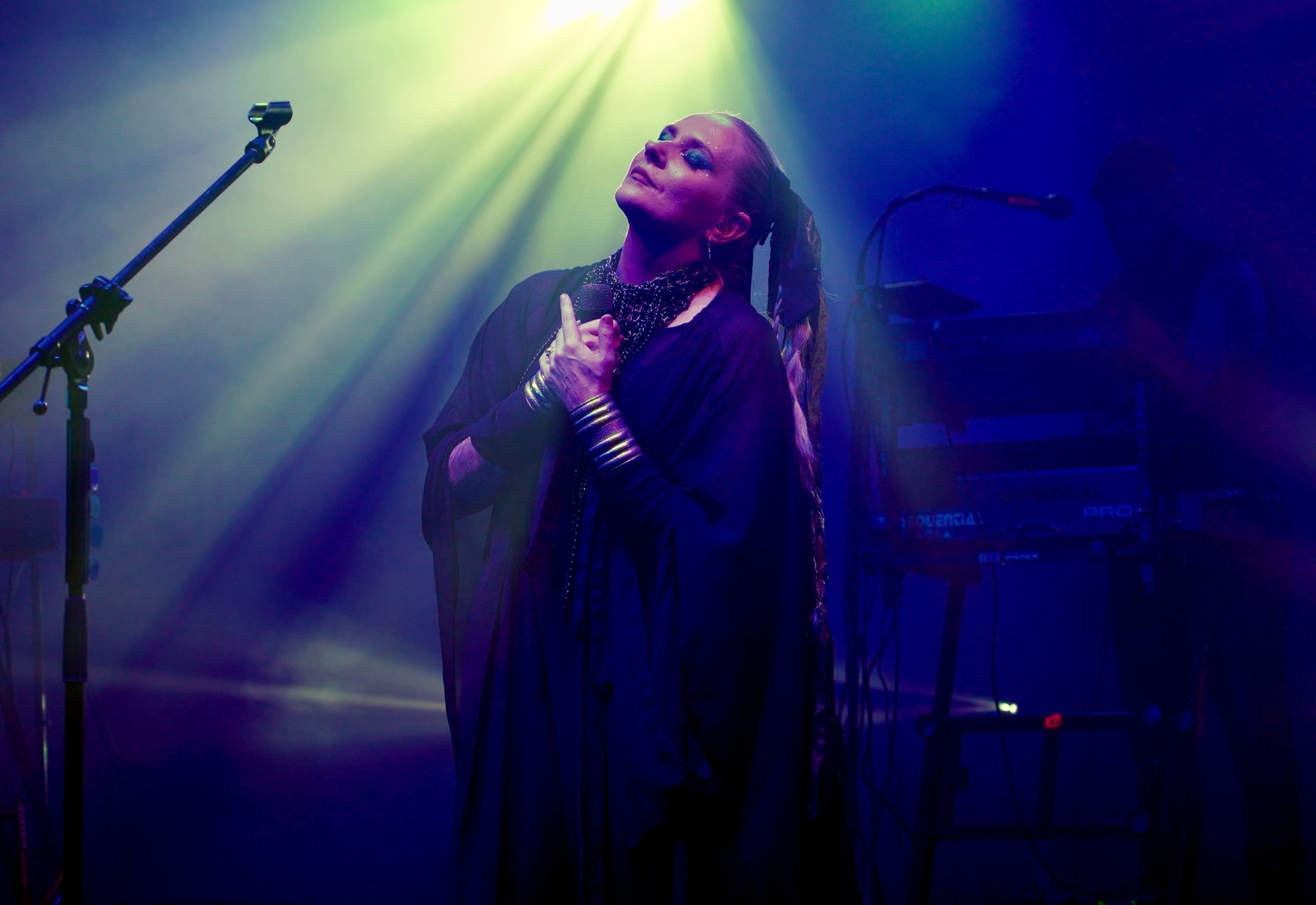 O artistă prinsă într-un singur fascicul de scenă, în timpul unui concert live — Pe scenă, în fascicul — 2026